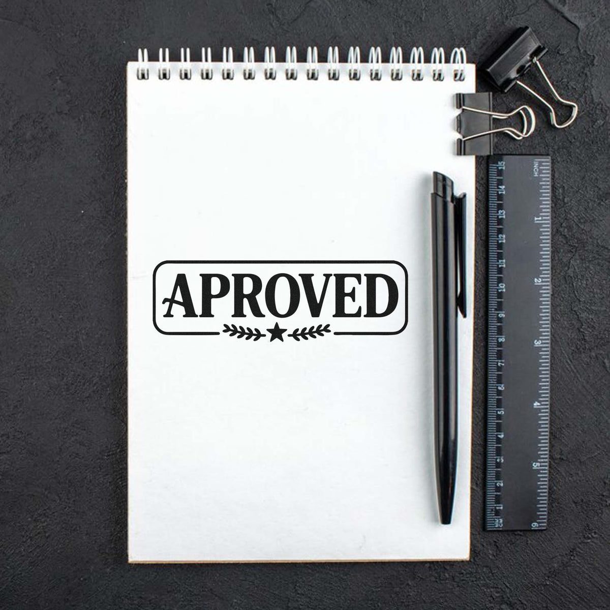 Approved rubber stamp imprint on notepad with pen and ruler for office document marking.