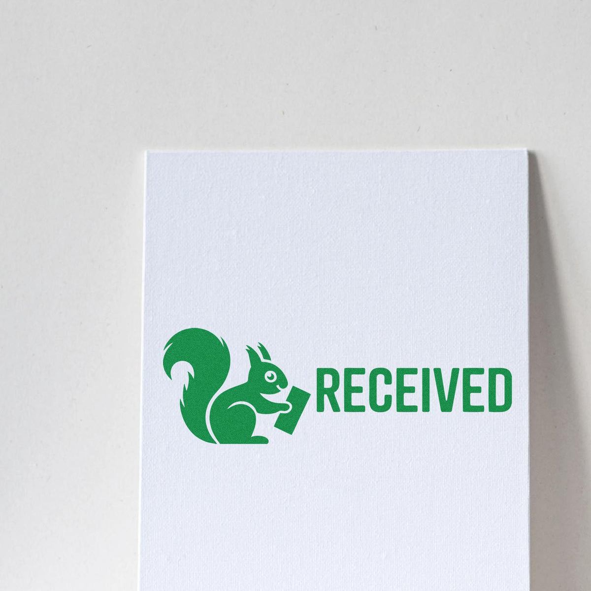 Custom RECEIVED rubber stamp with squirrel logo on white paper for office document processing