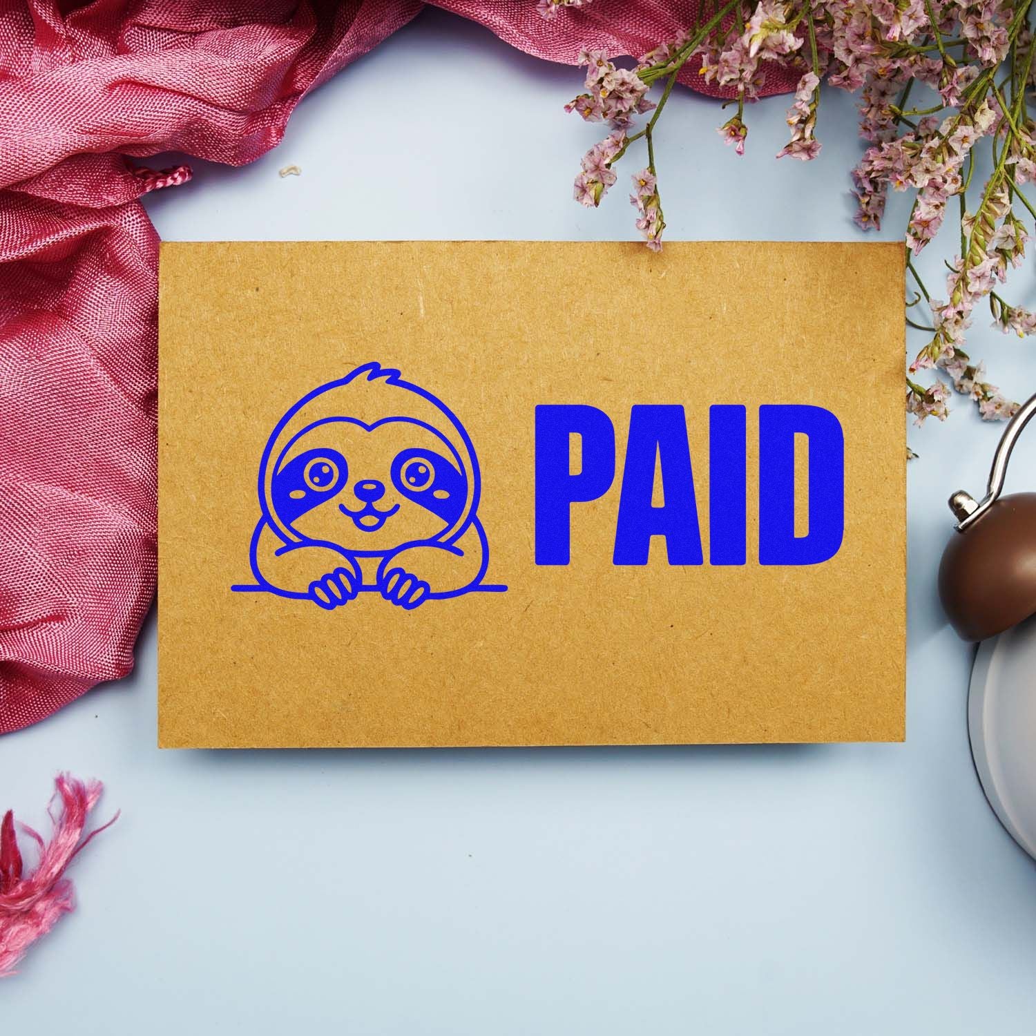 Sloth PAID rubber stamp design on kraft paper envelope, ideal for business mail, billing, and packaging.