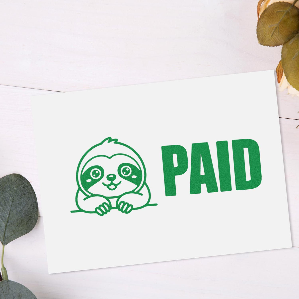 Green PAID rubber stamp with cute sloth design for invoices, receipts, and office paperwork.