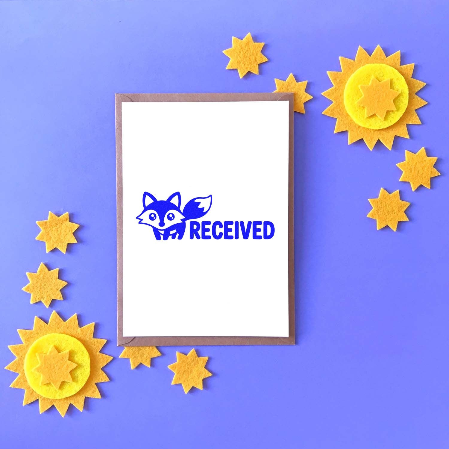 Fox RECEIVED rubber stamp on blank card, with sunburst star decorations on a purple craft background.