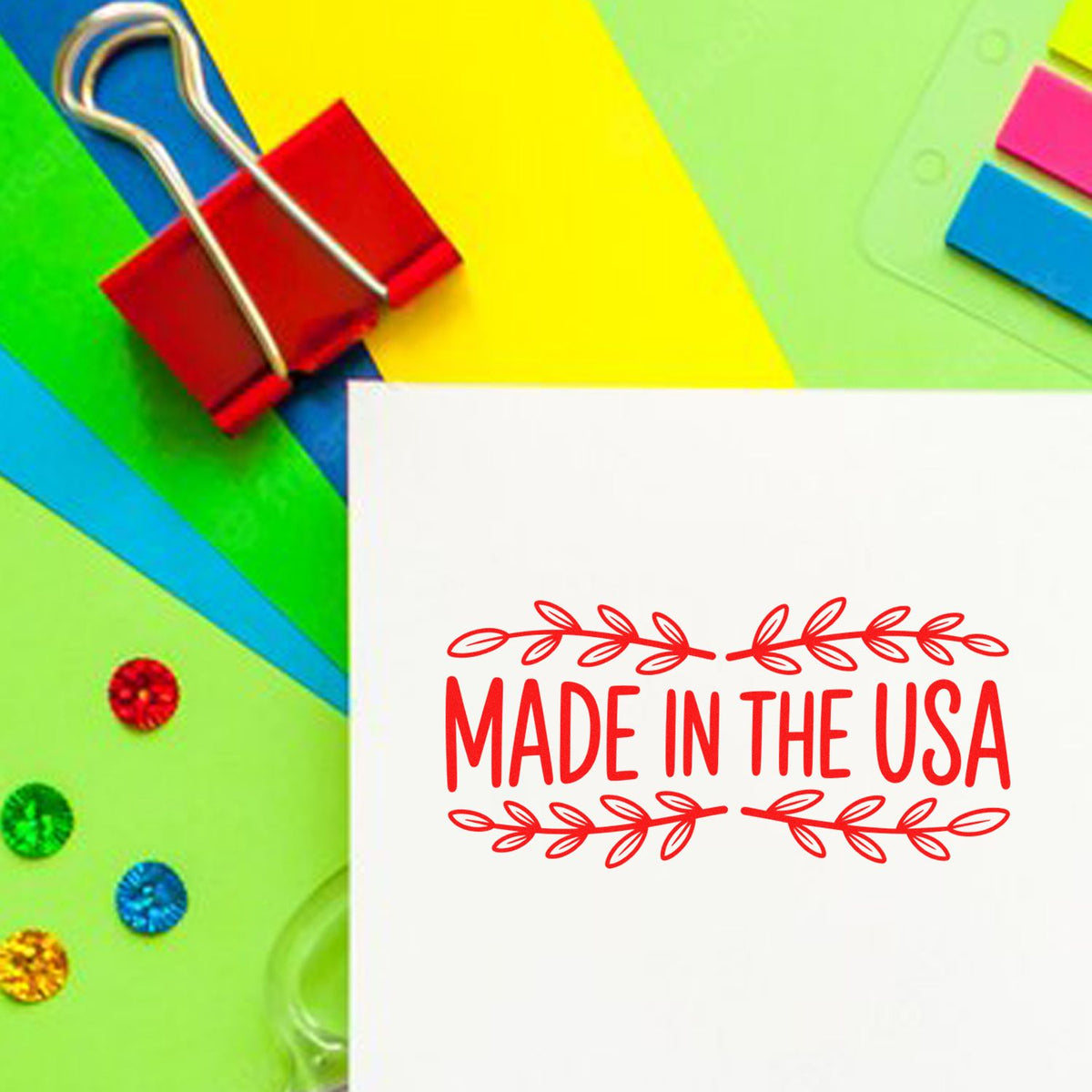 Made in the USA rubber stamp imprint on white paper with colorful office supplies, ideal for packaging, crafts, and product labeling