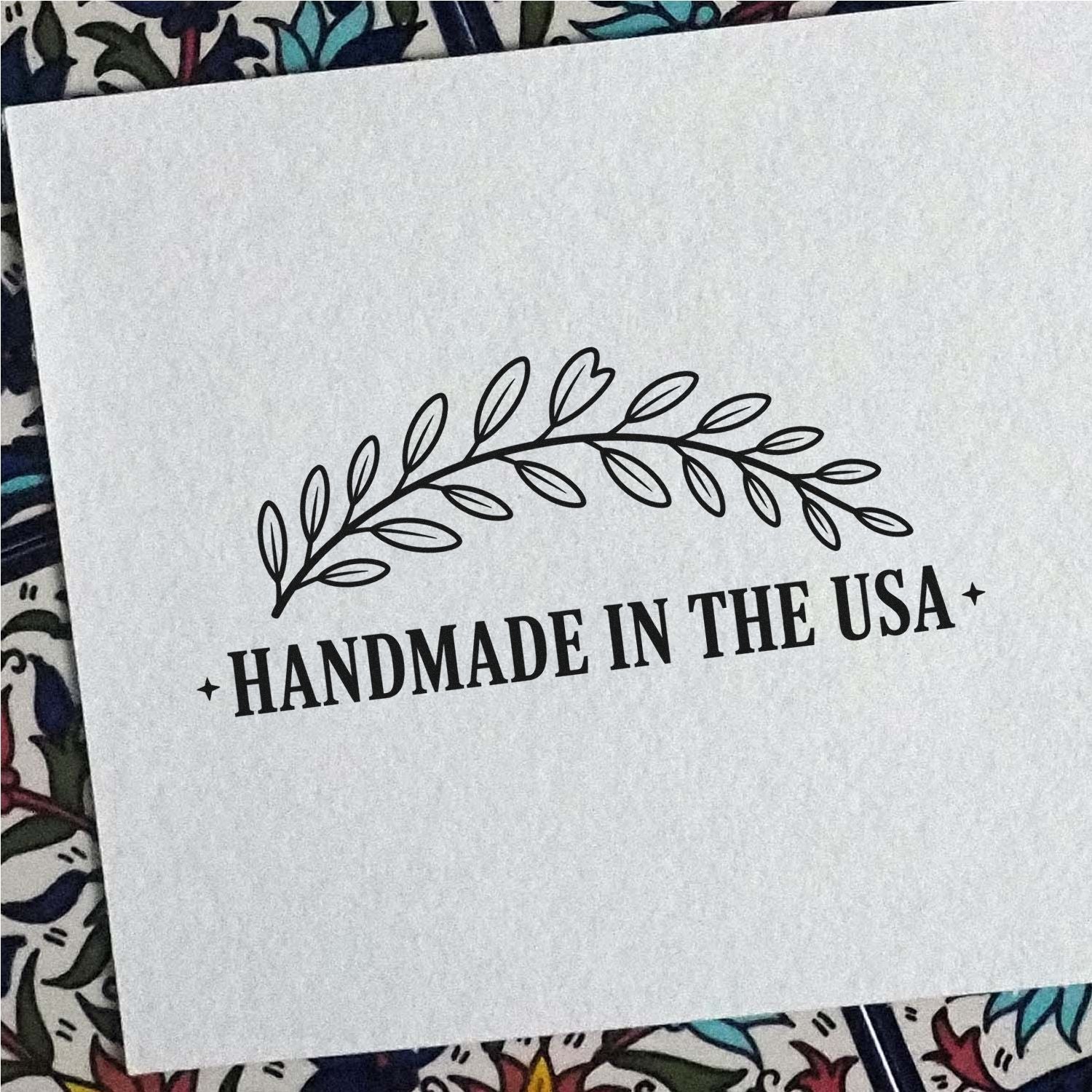 Custom rubber stamp impression with leafy branch and Handmade in the USA text for product packaging and branding.
