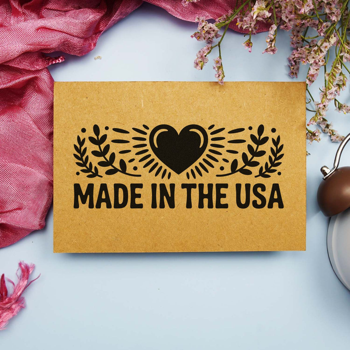 Made in the USA rubber stamp design with heart and laurel leaves on kraft paper, styled as a handmade product mockup.