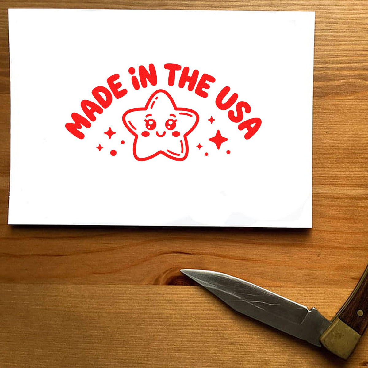 Made in the USA rubber stamp impression with smiling star graphic, shown in red ink on paper.