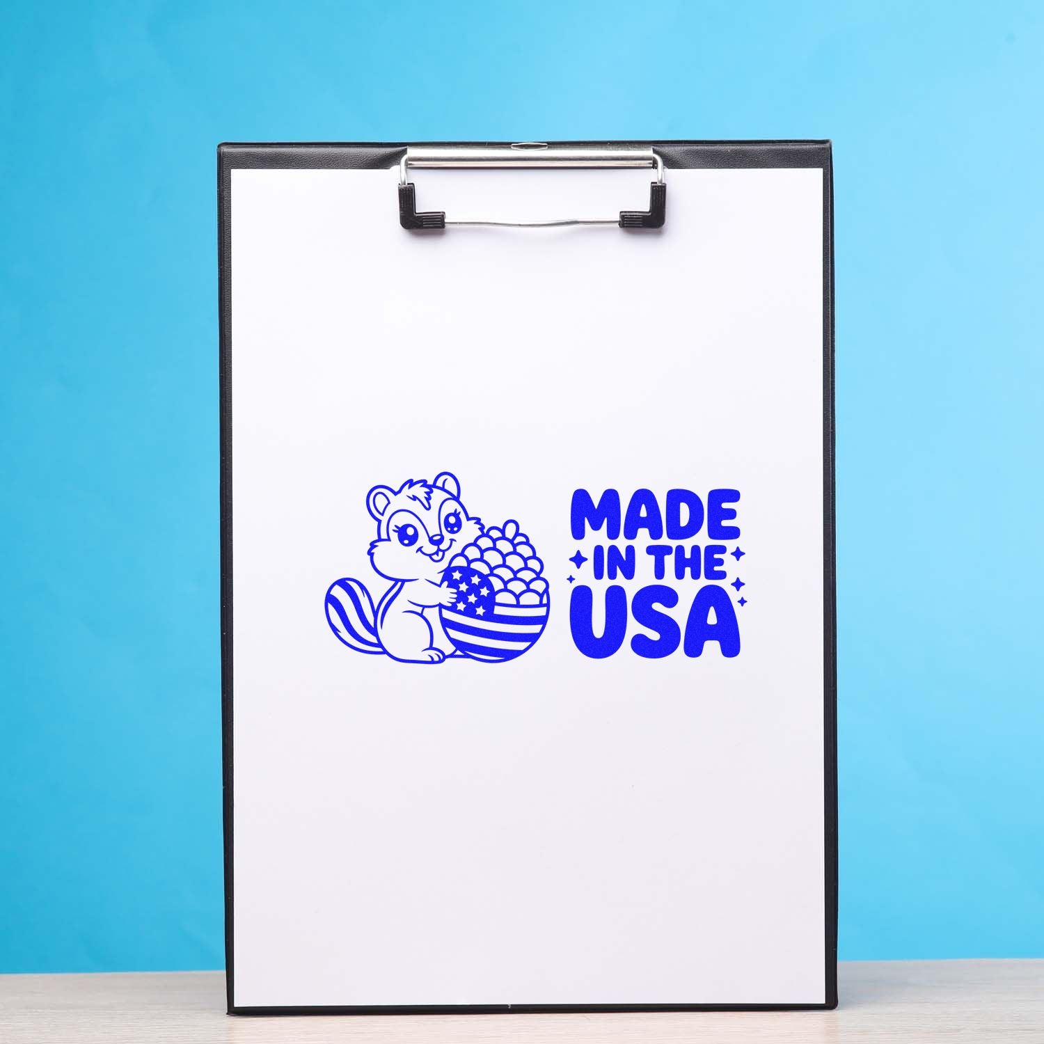 Made in USA rubber stamp design with patriotic squirrel and American flag acorn on clipboard.