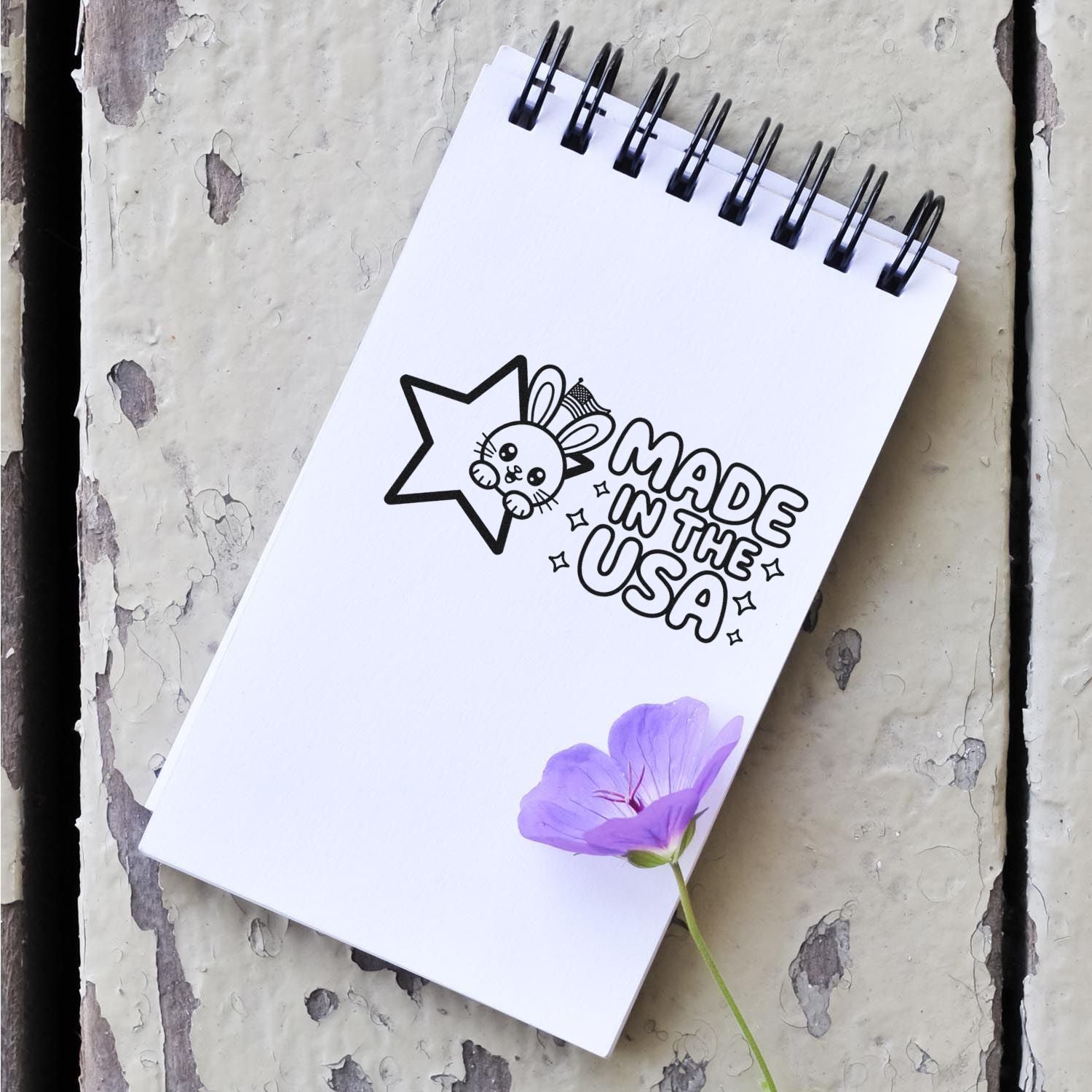 Made in the USA rubber stamp design on a notebook, featuring a cute bunny star logo for custom product branding.