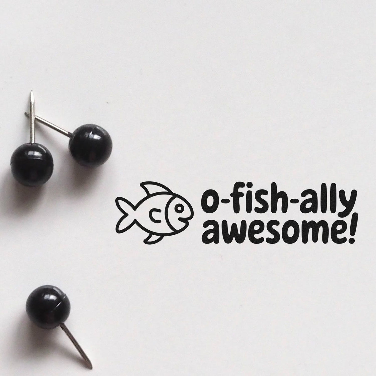 O-fish-ally awesome fish rubber stamp design with push pins on white background, ideal for playful teacher or office use.