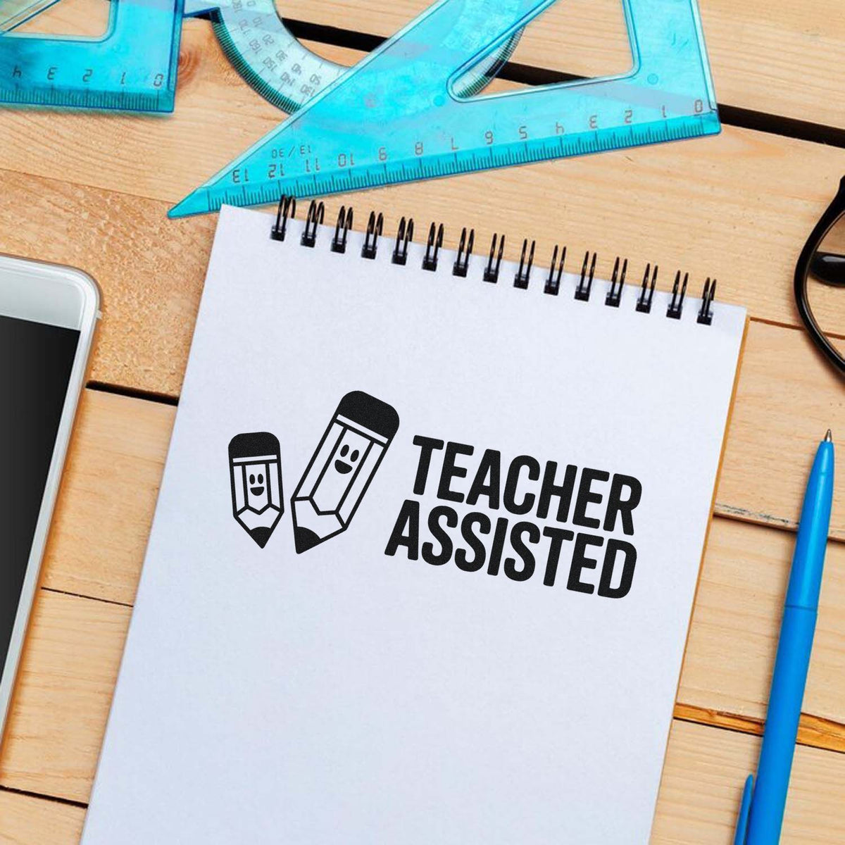 Teacher Assisted rubber stamp mockup on notebook with school supplies for classroom grading and teacher feedback.