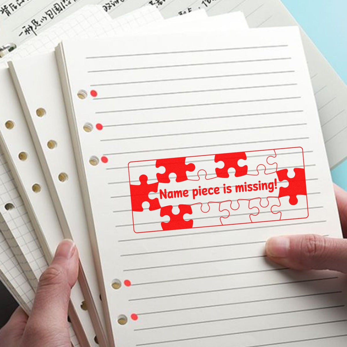 Custom rubber stamp with puzzle design for marking missing name pieces on notebook pages