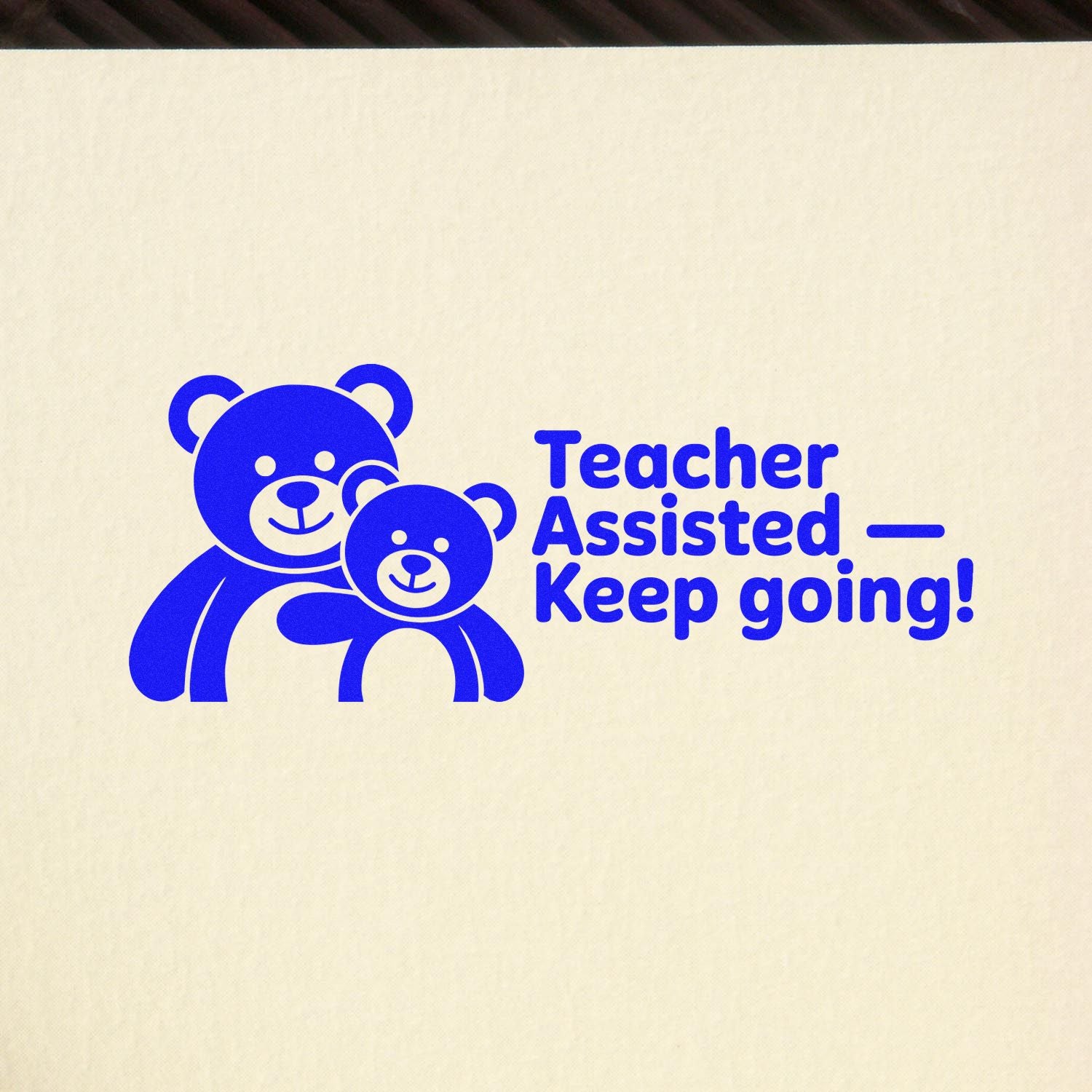 Blue teacher assisted keep going rubber stamp with teddy bear graphic for classroom encouragement.