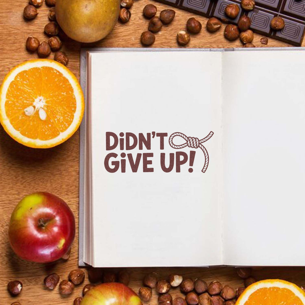 Motivational rubber stamp reading 'Didnt Give Up!' on an open journal page, ideal for crafting, journaling, and scrapbooking.