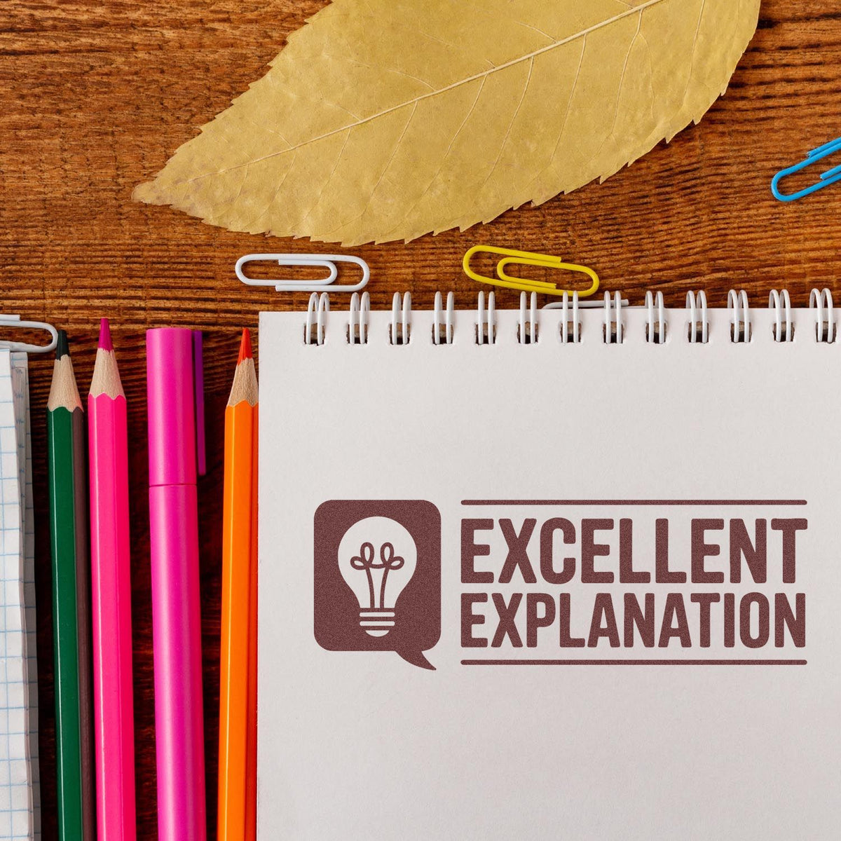 Excellent Explanation rubber stamp on notebook with pencils and paper clips, ideal for teacher feedback and classroom grading.