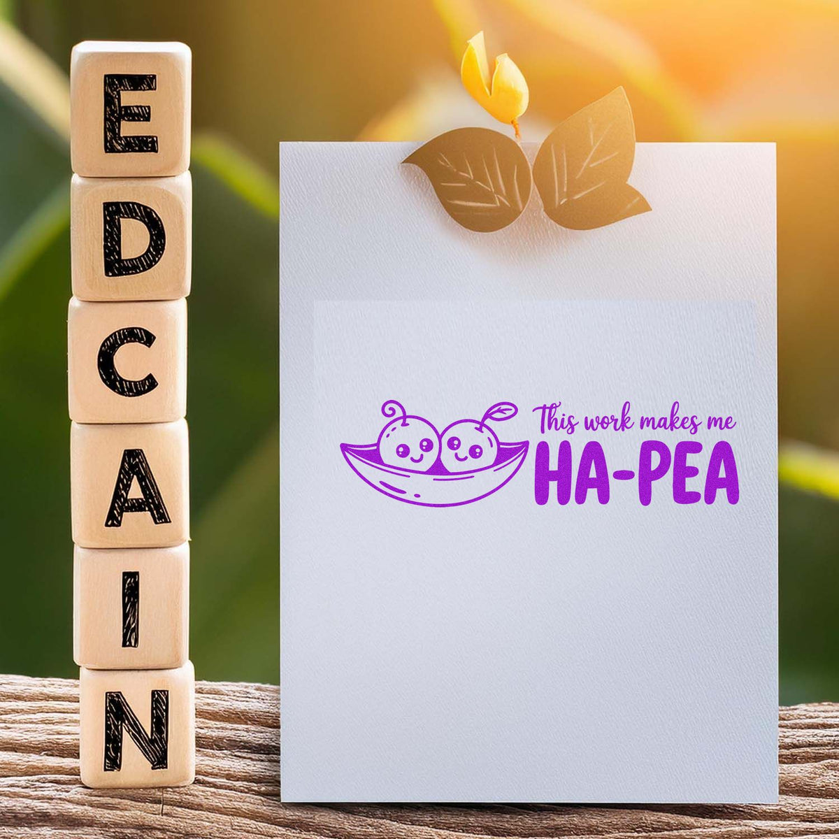 Custom rubber stamp design on card with This work makes me HA-PEA pea pod graphic, beside wooden alphabet blocks.