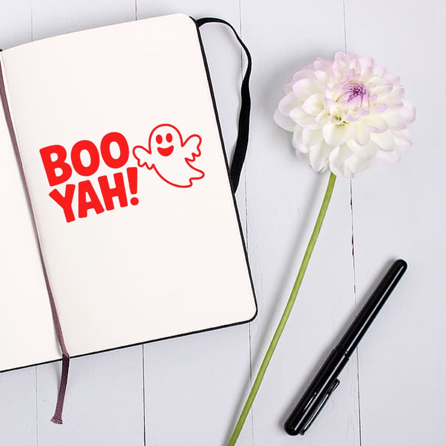 Custom rubber stamp design mockup with playful Boo Yah ghost graphic on notebook, ideal for Halloween stationery and crafts.