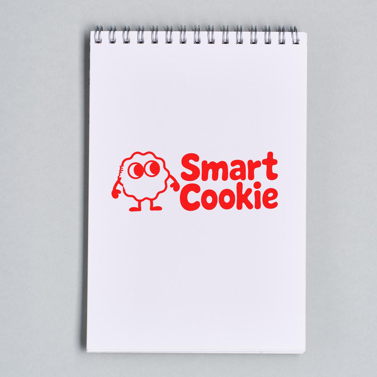 Smart Cookie custom rubber stamp design in red on a notebook, featuring a cute cookie character for branding and packaging.