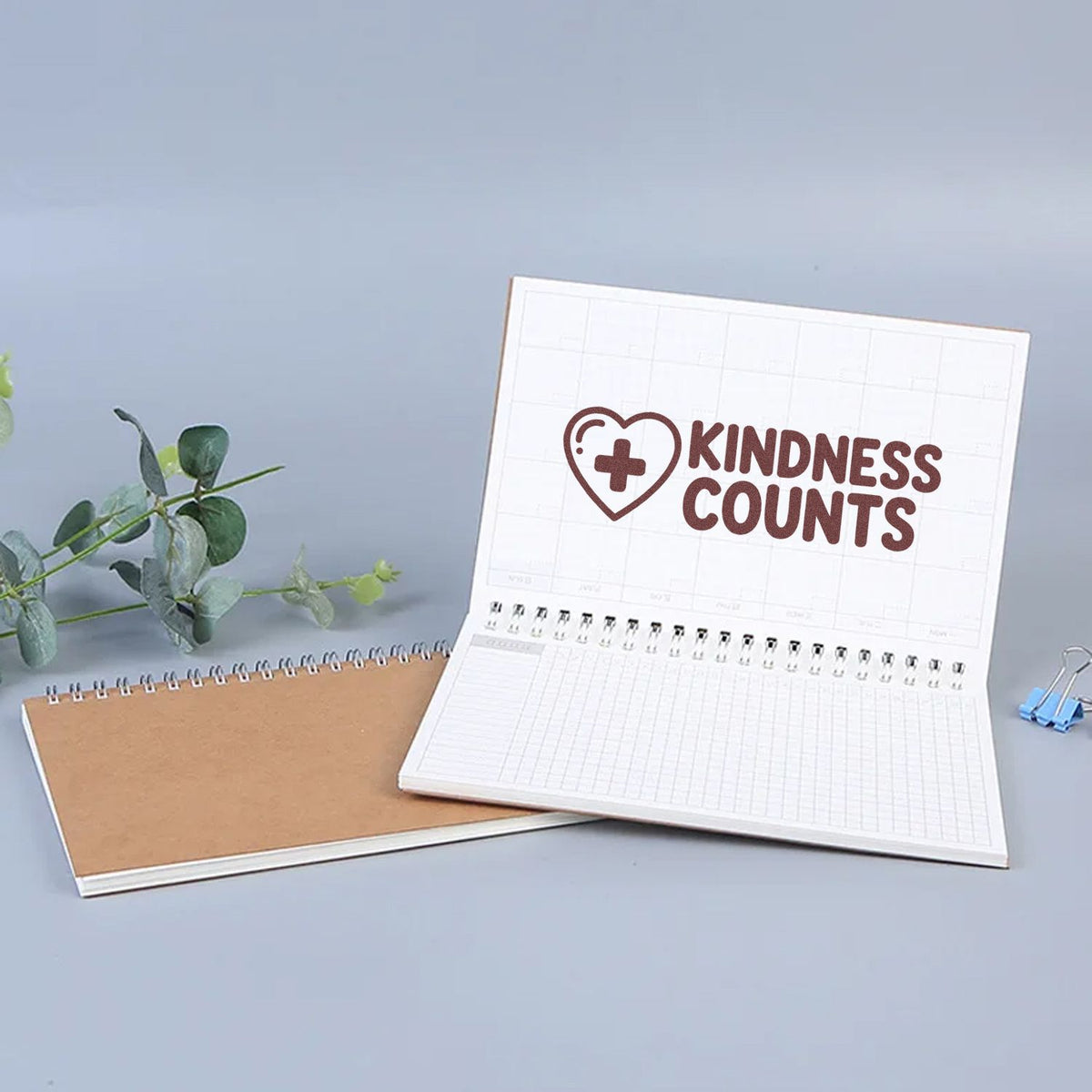 Kindness Counts rubber stamp on planner page, featuring a heart and cross icon for inspirational journaling and crafts.
