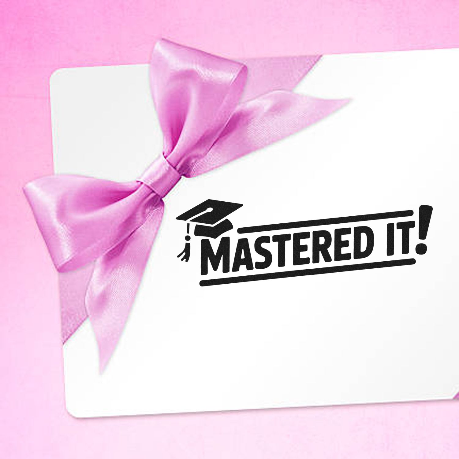 Custom rubber stamp design: MASTERED IT! graduation stamp on a pink gift card with bow, perfect for student achievement.