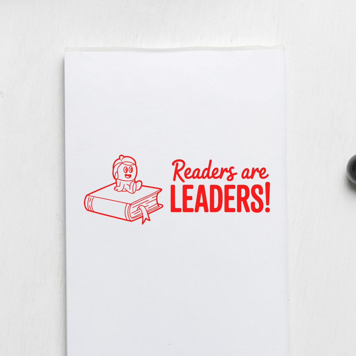Readers are Leaders rubber stamp design with child sitting on a book, ideal for teacher and literacy stamping.