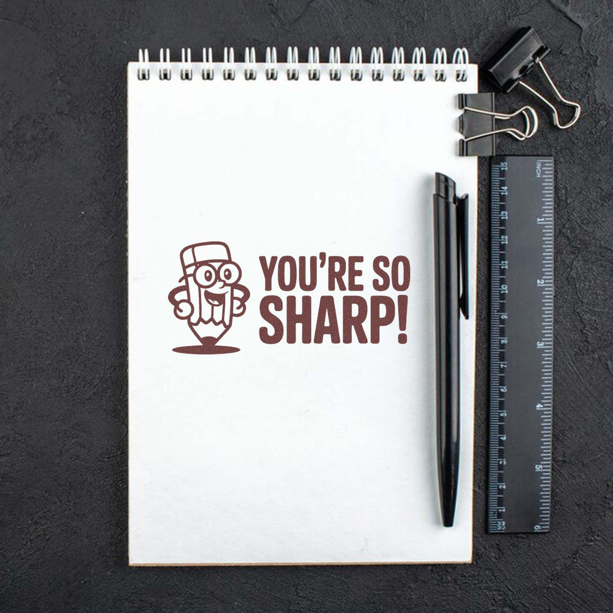 Youre So Sharp! pencil-themed rubber stamp displayed on a notebook, perfect for teacher grading and student encouragement.