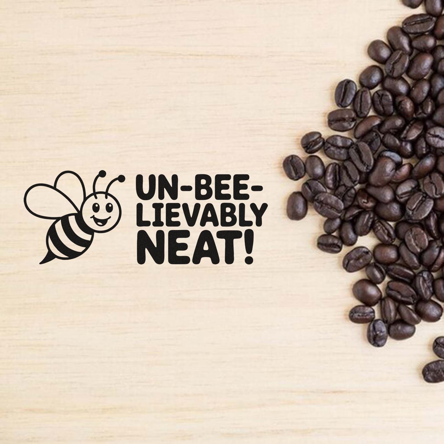 Bee rubber stamp with Un-bee-lievably neat! pun, shown beside coffee beans on wood background for coffee-themed crafts.