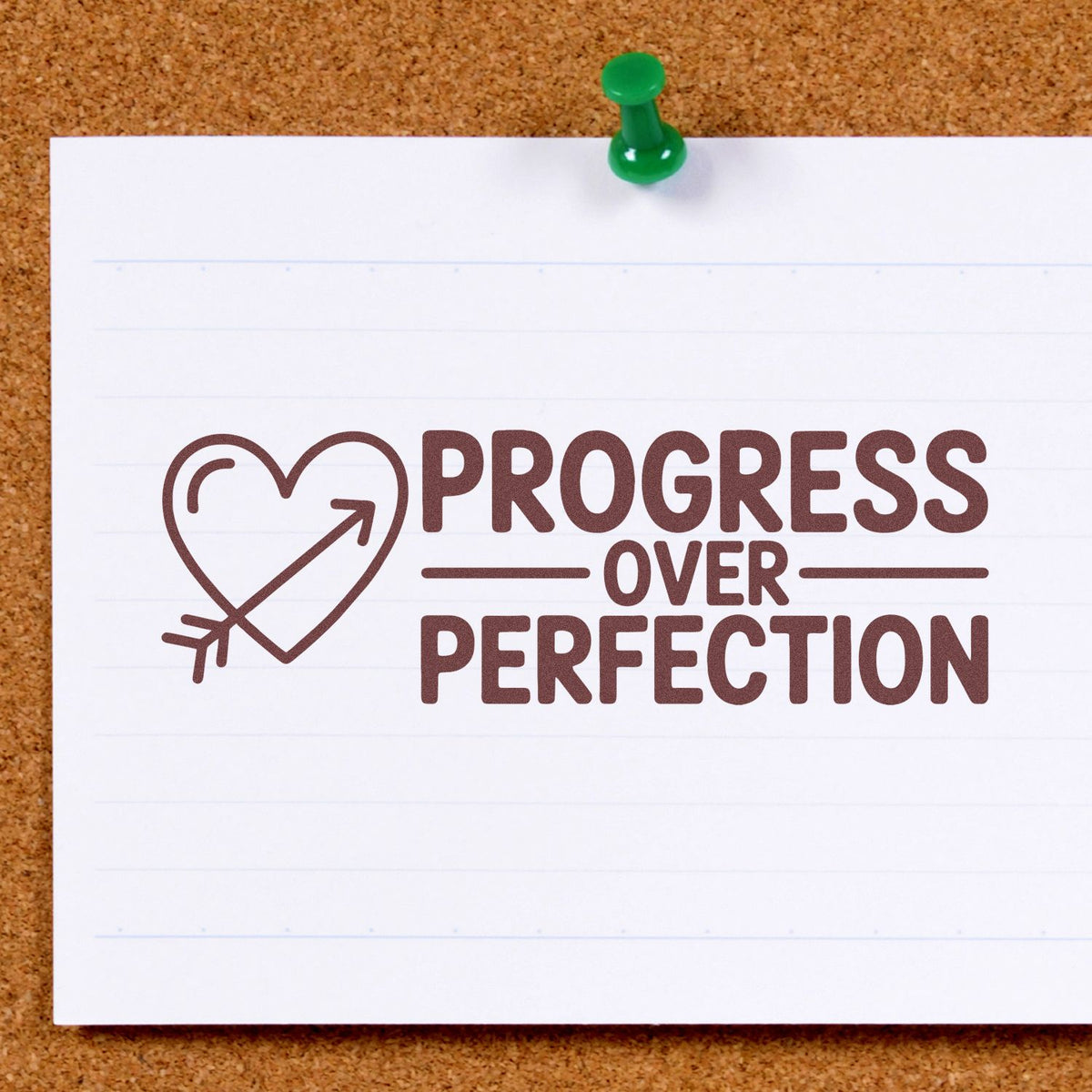 Progress Over Perfection rubber stamp impression with heart arrow, ideal for motivational journaling and craft projects.