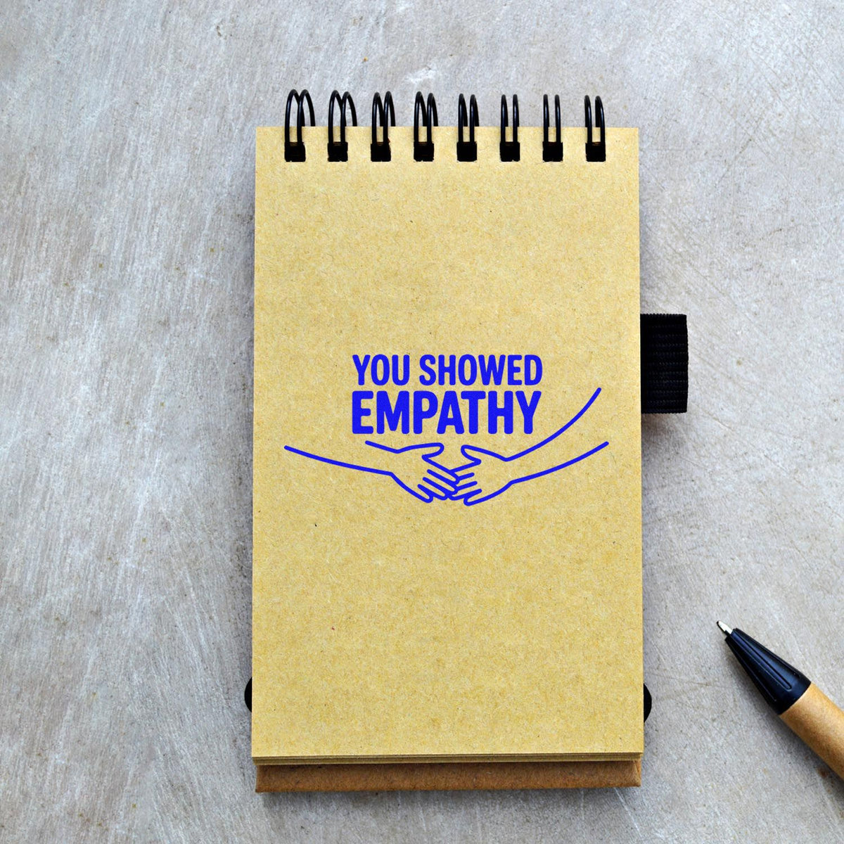 You showed empathy rubber stamp on notebook with handshake icon for appreciation and recognition messages.
