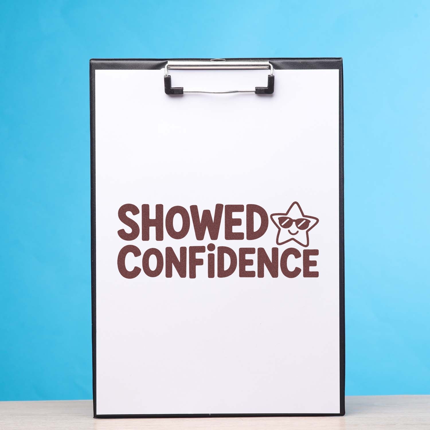 Motivational rubber stamp design reading Showed Confidence with star icon on clipboard.