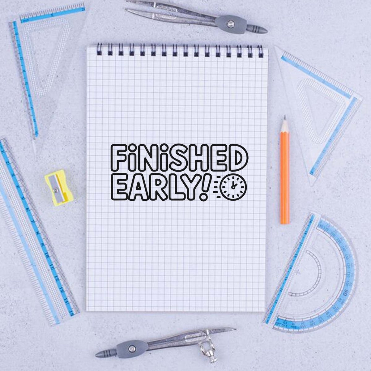 Custom rubber stamp design reading Finished Early! on a notebook, surrounded by school supplies and drafting tools.