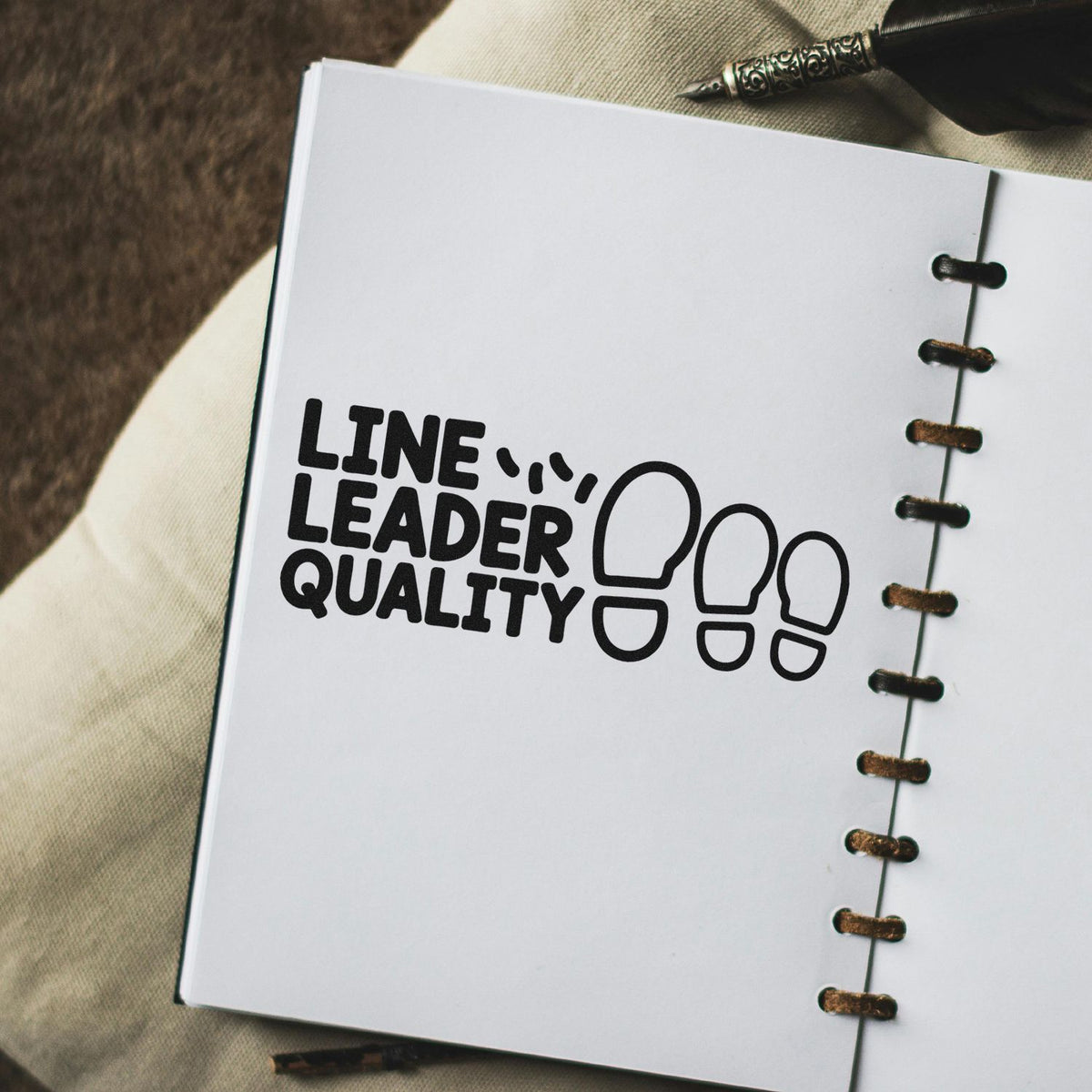 Custom rubber stamp reading Line Leader Quality with footprint design on a notebook page.
