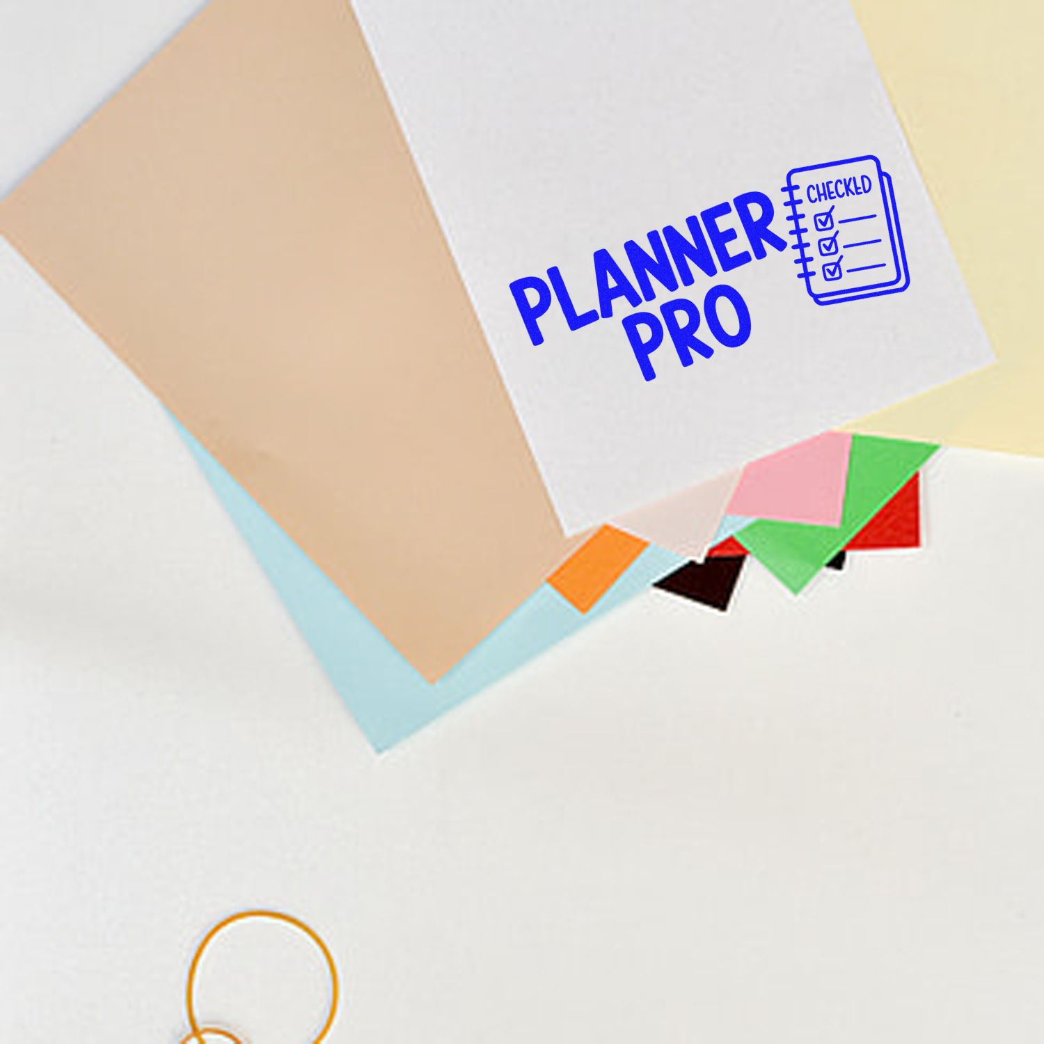 Blue Planner Pro checked rubber stamp on paper with sticky notes, ideal for organizing planners and to-do lists.
