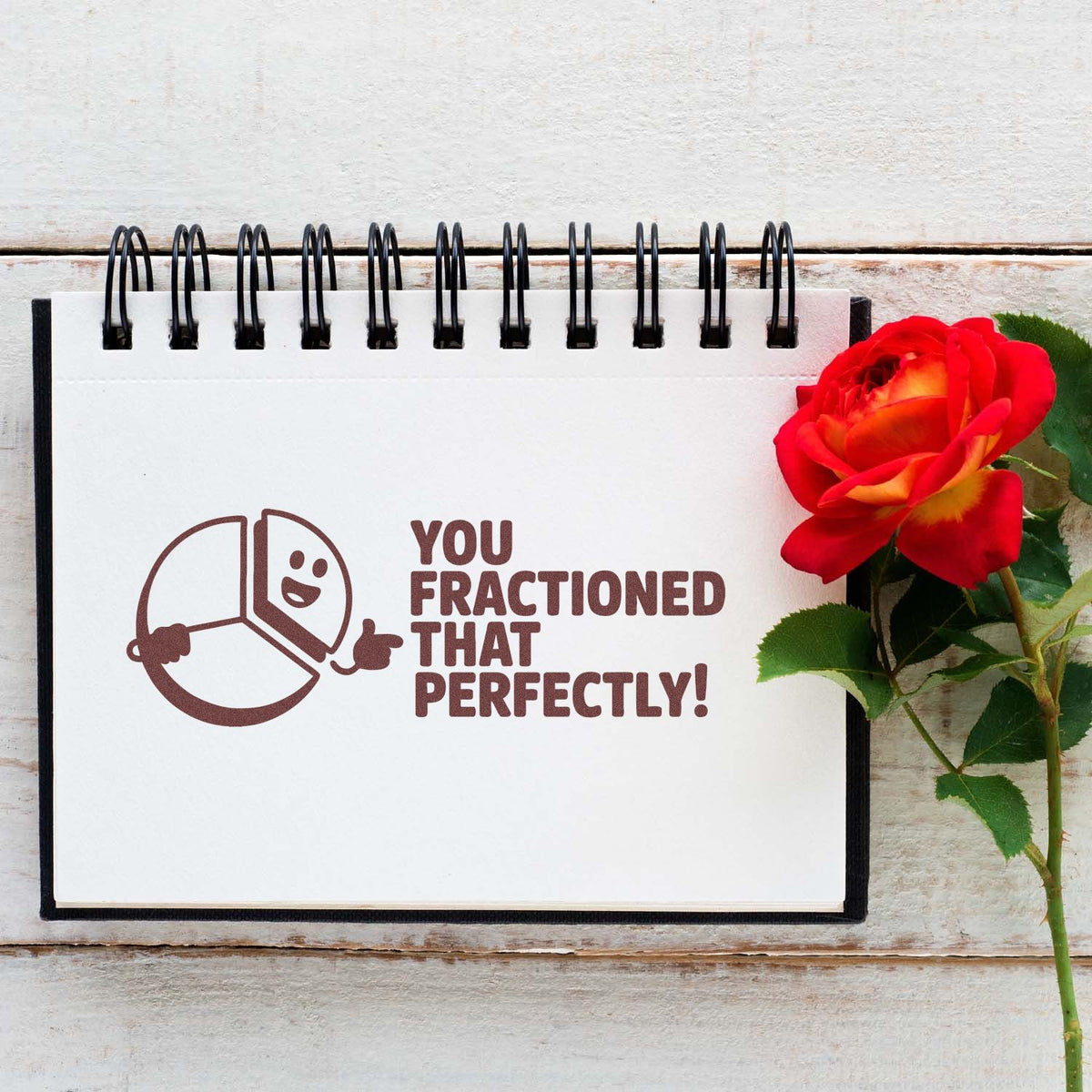 Fraction math teacher rubber stamp reading You fractioned that perfectly! on notebook with rose.