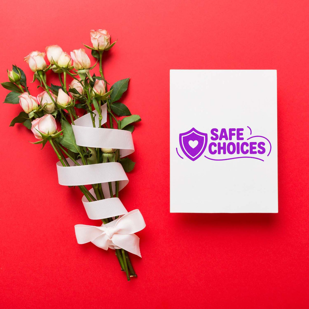 Custom rubber stamp with Safe Choices logo on a white card beside a rose bouquet on a red background.
