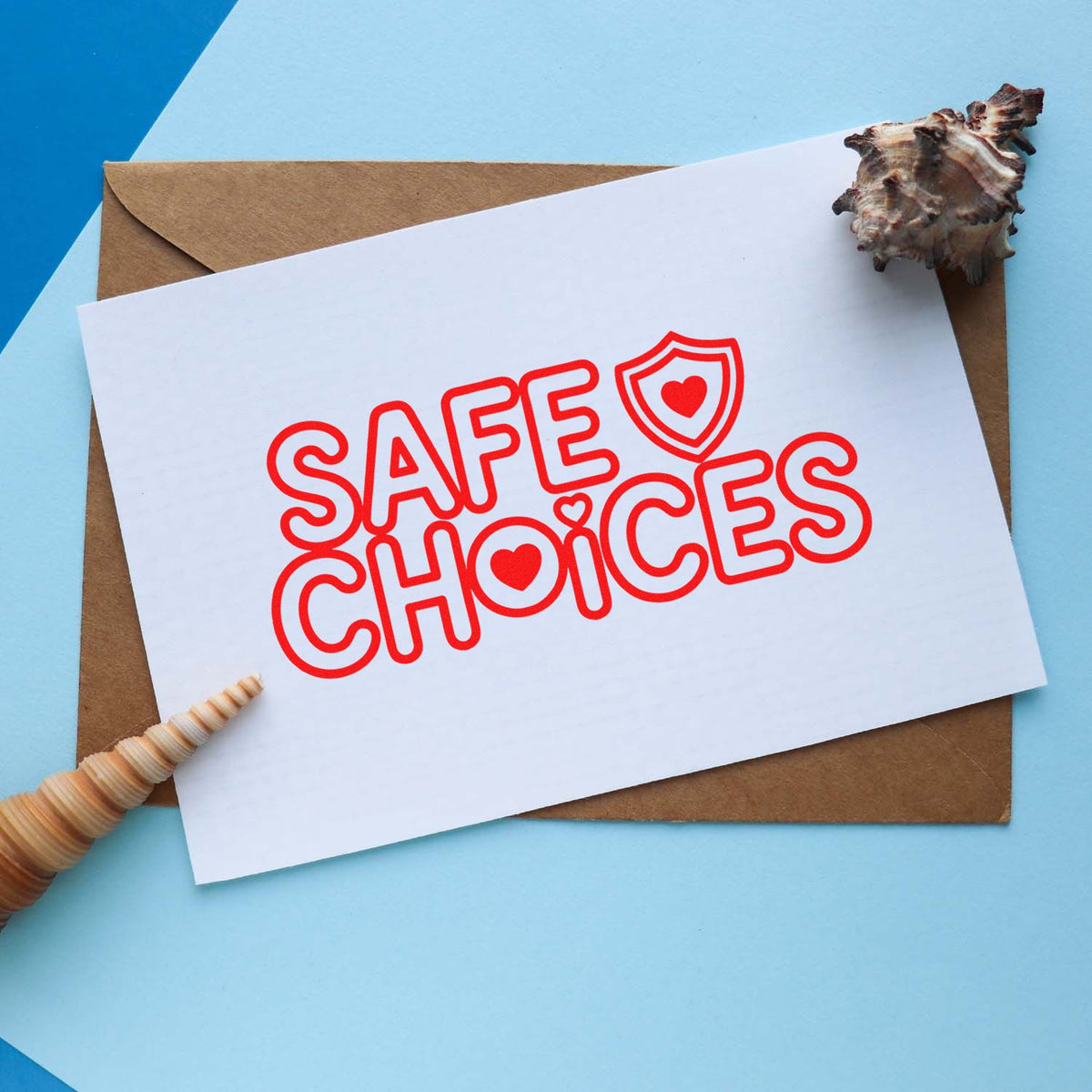 Safe Choices rubber stamp with heart shield icon on card, perfect for packaging, stationery, and beach-themed branding.