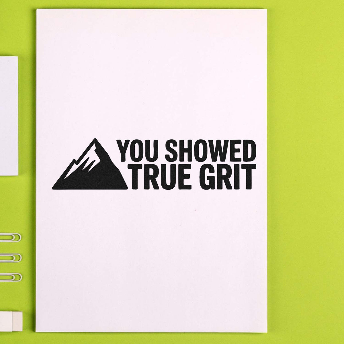 Mountain rubber stamp reading You Showed True Grit on notebook, ideal for motivational reward and recognition.