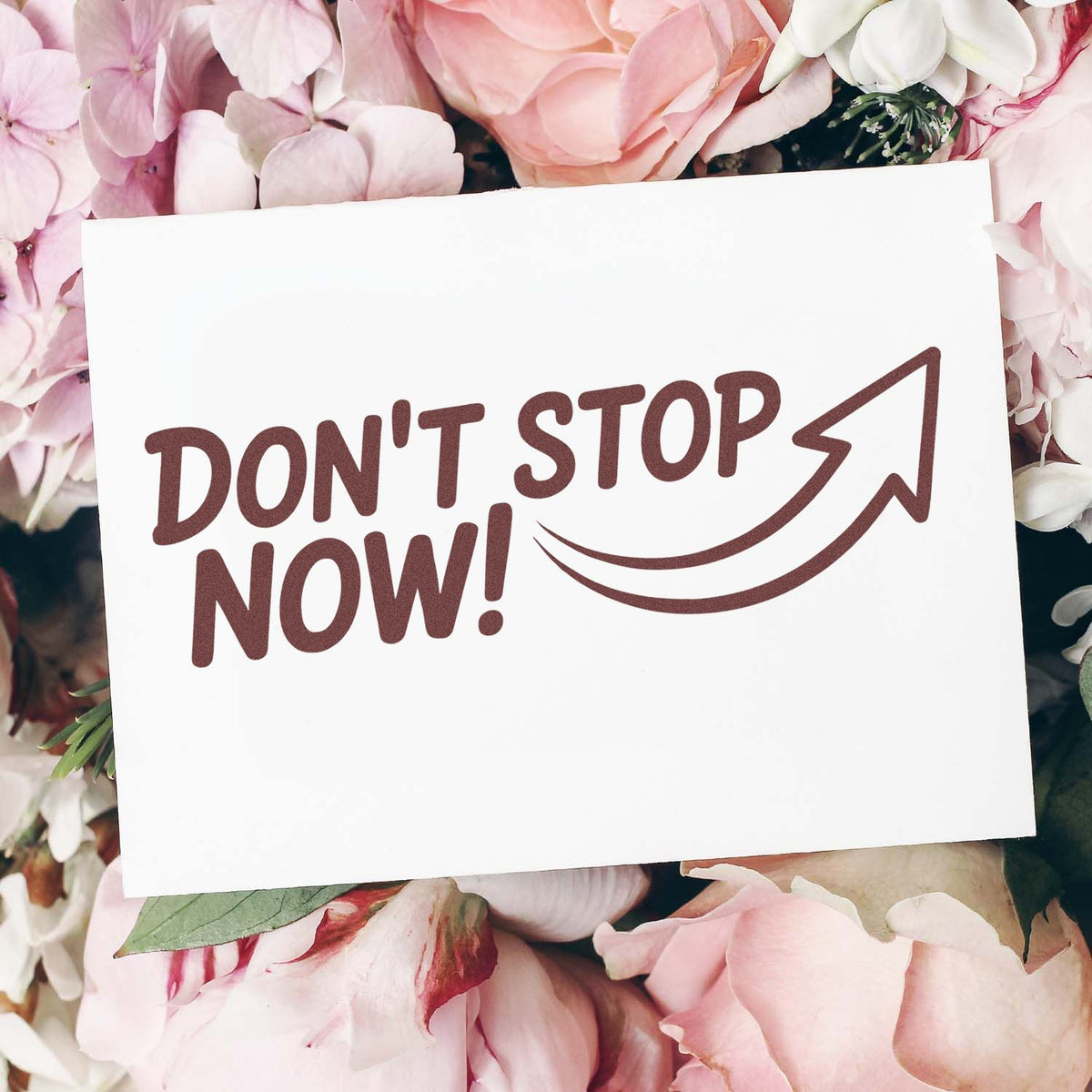 Don't Stop Now rubber stamp design with arrow on floral card mockup for motivational crafting and handmade business branding.