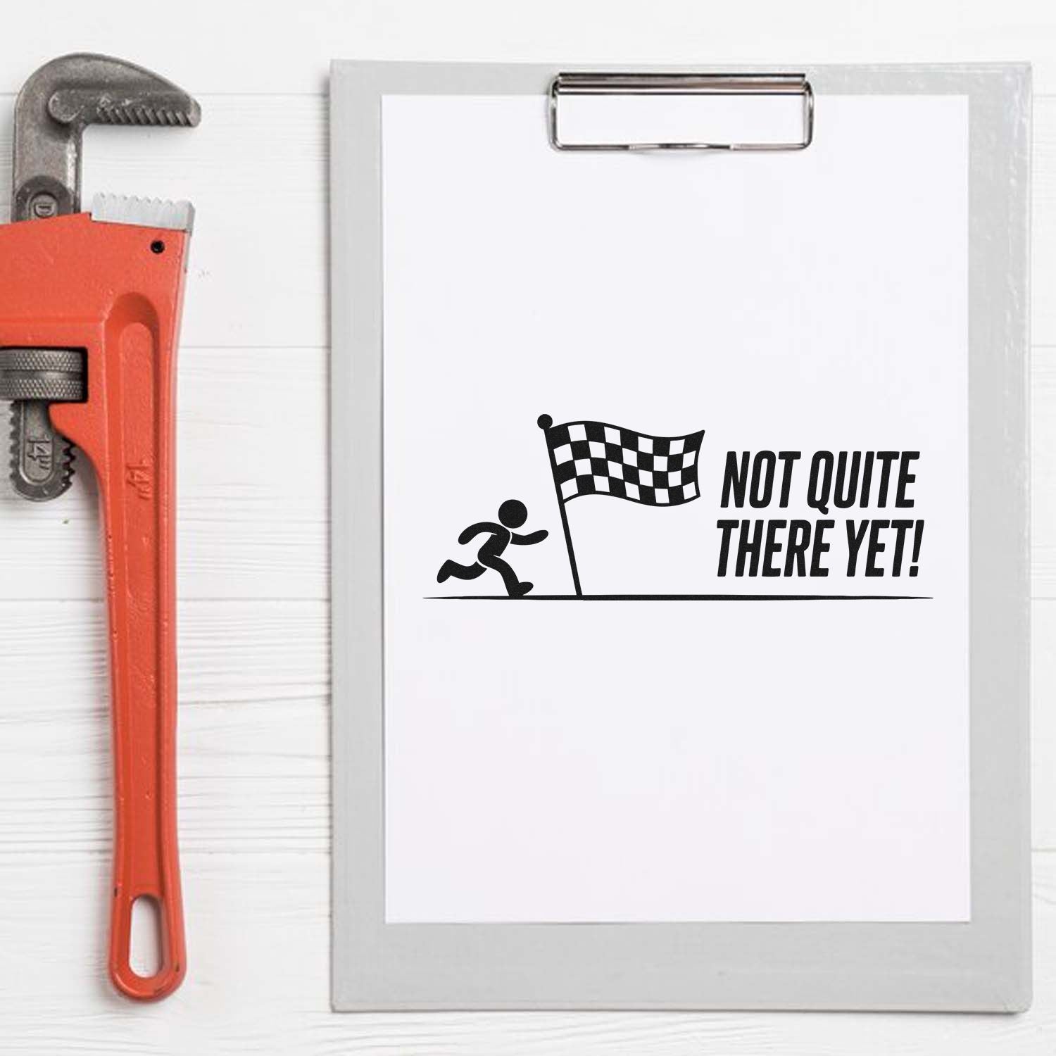 Motivational rubber stamp design reading Not Quite There Yet! with runner and finish flag for office or teacher use.