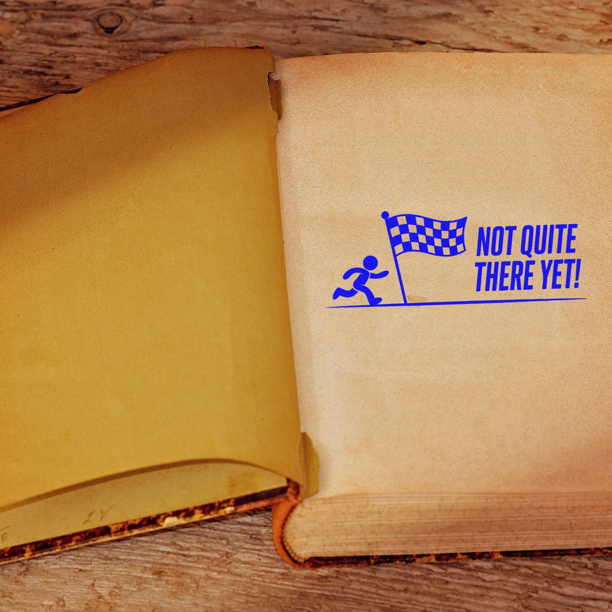 Not Quite There Yet rubber stamp on open book, ideal for motivational journaling, progress tracking, and encouragement.