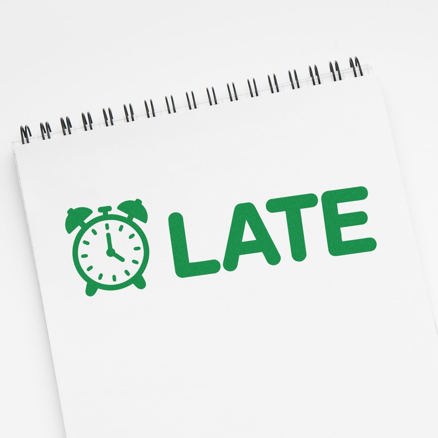 Late rubber stamp with clock icon on notebook page for marking tardy tasks, school papers, or office documents.