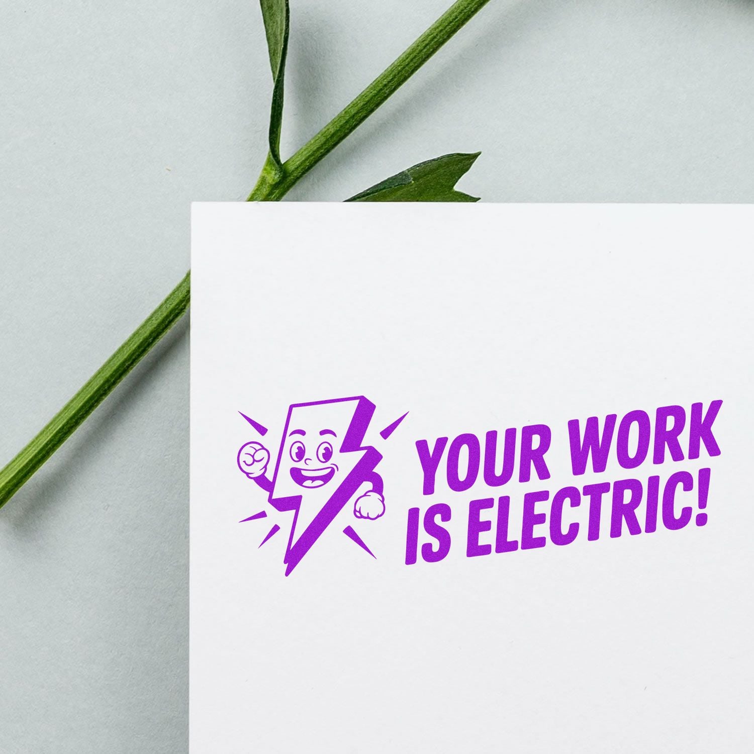Purple custom rubber stamp design reading Your Work Is Electric! with lightning character on white card.