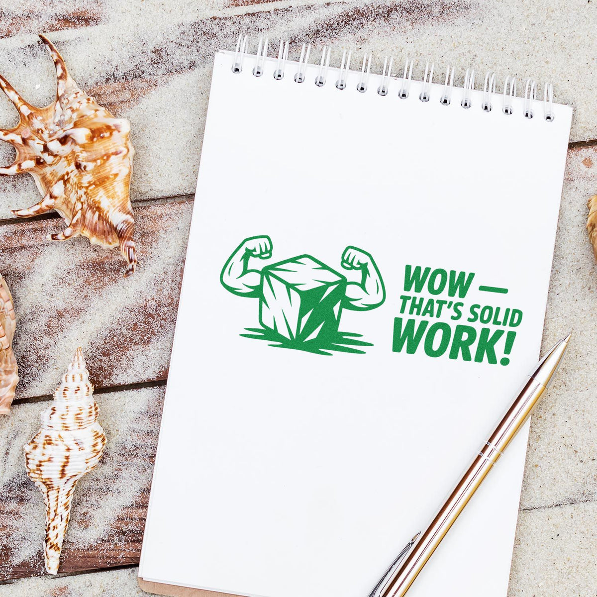 Beach notebook mockup with green rubber stamp design: flexing rock and Wowthats solid work! message.