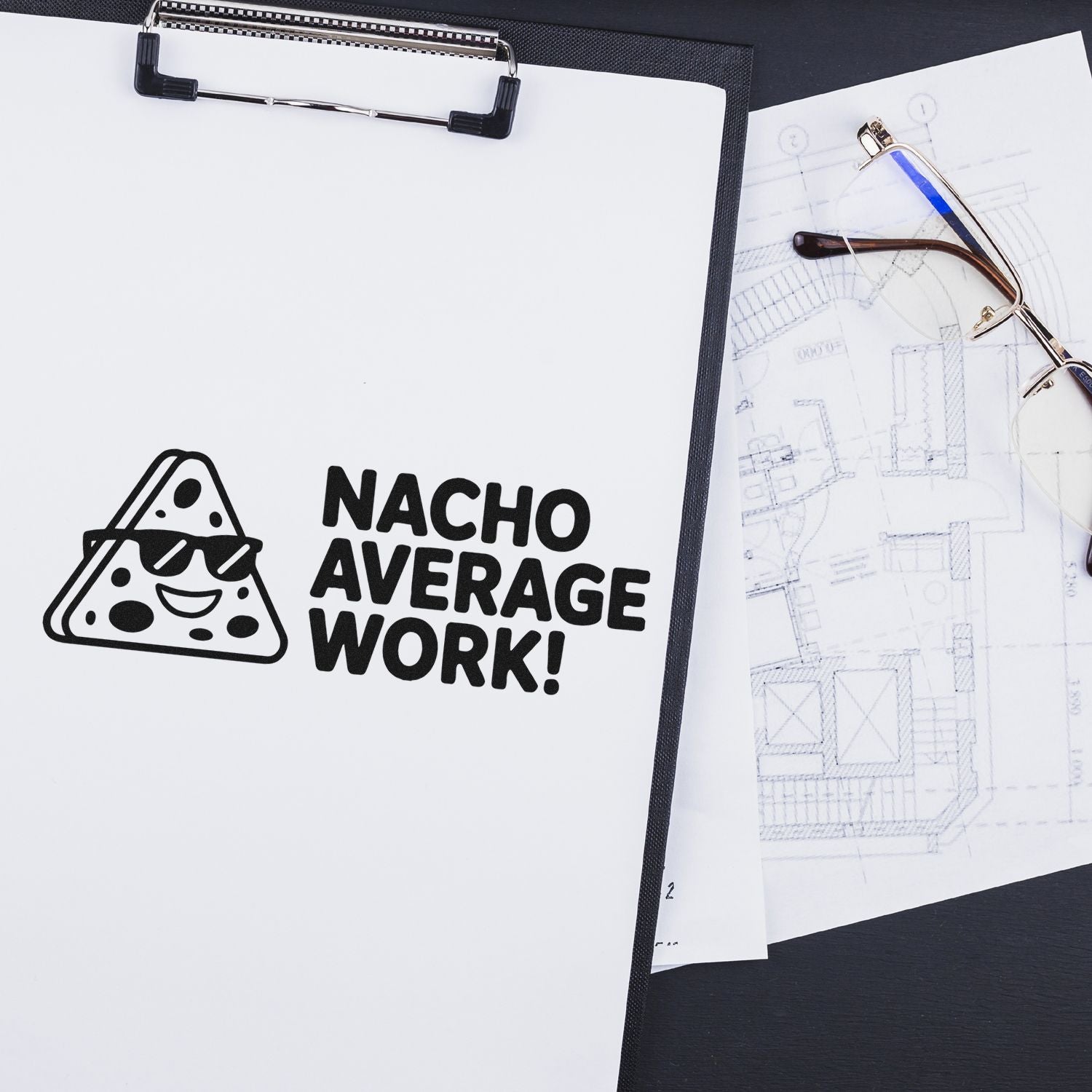 Custom rubber stamp design reading Nacho Average Work! with nacho icon on clipboard beside eyeglasses and blueprints.