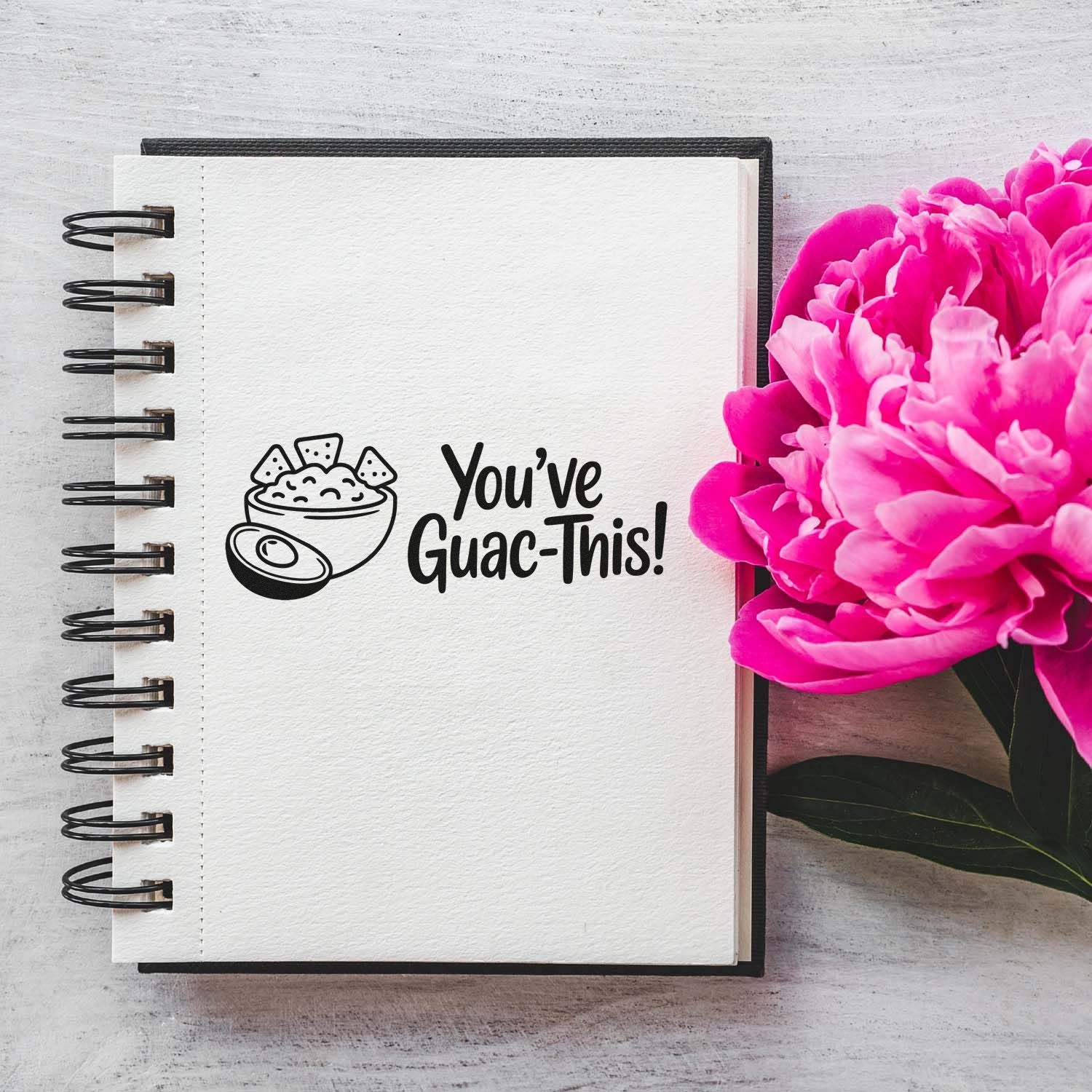 Fun custom rubber stamp design with guacamole bowl icon and Youve Guac-This! message on a notebook.