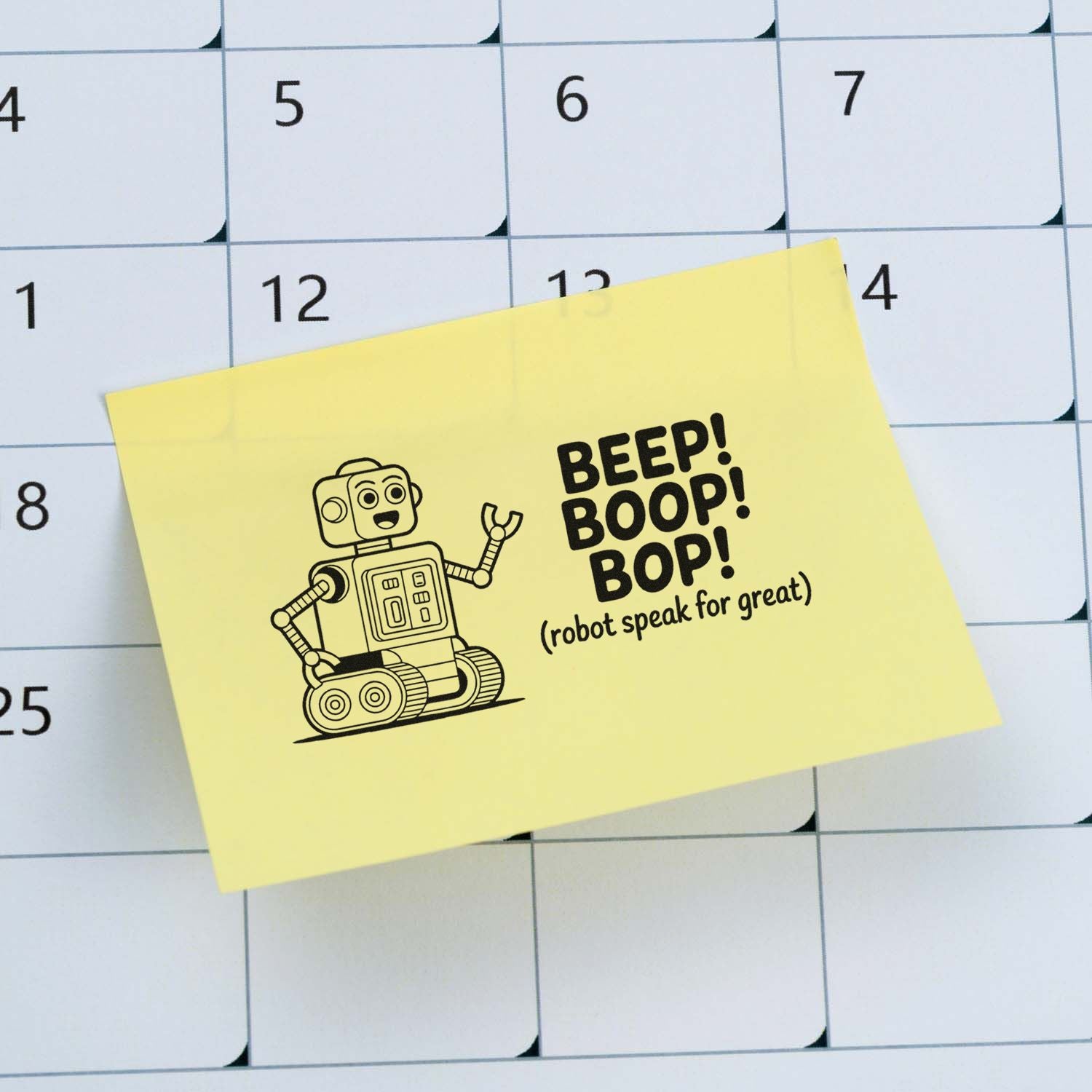Robot rubber stamp design on yellow sticky note over calendar, reading Beep! Boop! Bop! for fun planner decor.