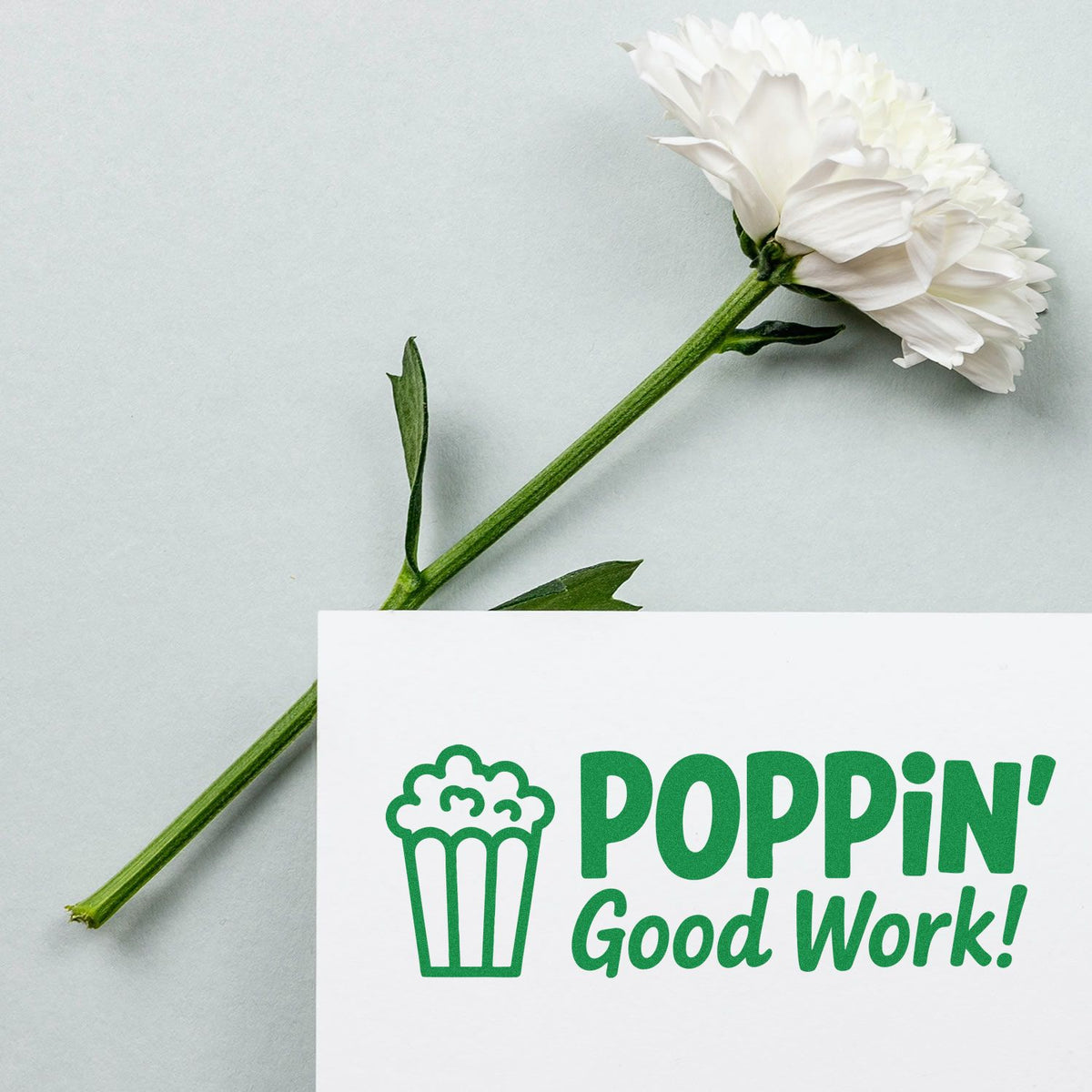 Rubber stamp design with popcorn icon and POPPIN Good Work! message beside a white flower on a light background.