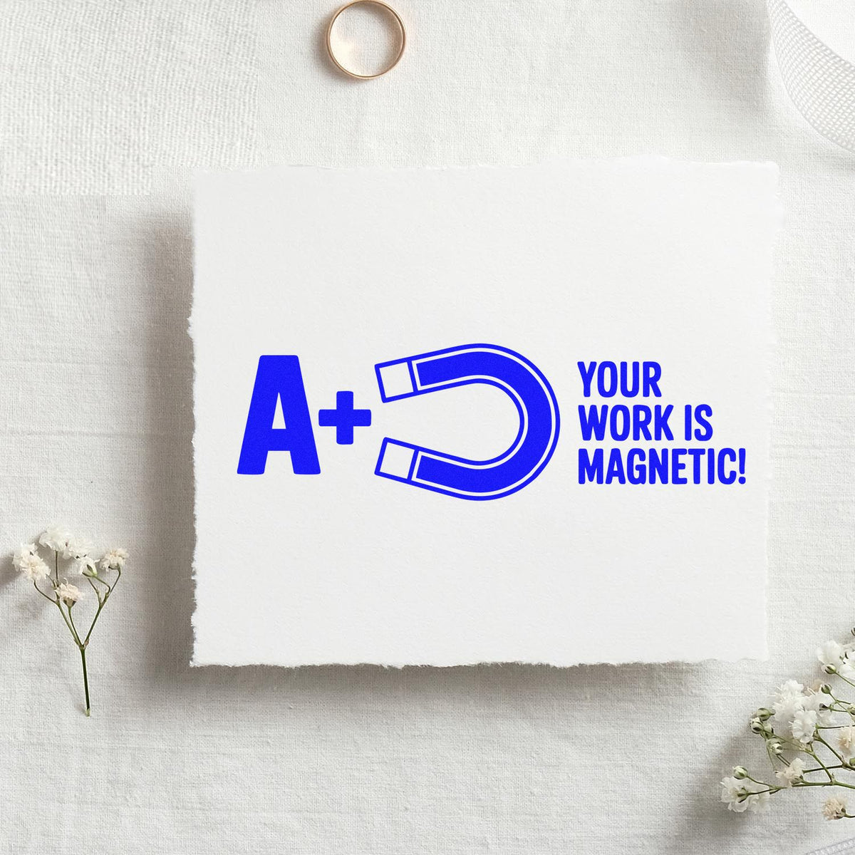 Custom rubber stamp design with A+ magnet and Your work is magnetic! on a paper mockup for teacher reward stamping.