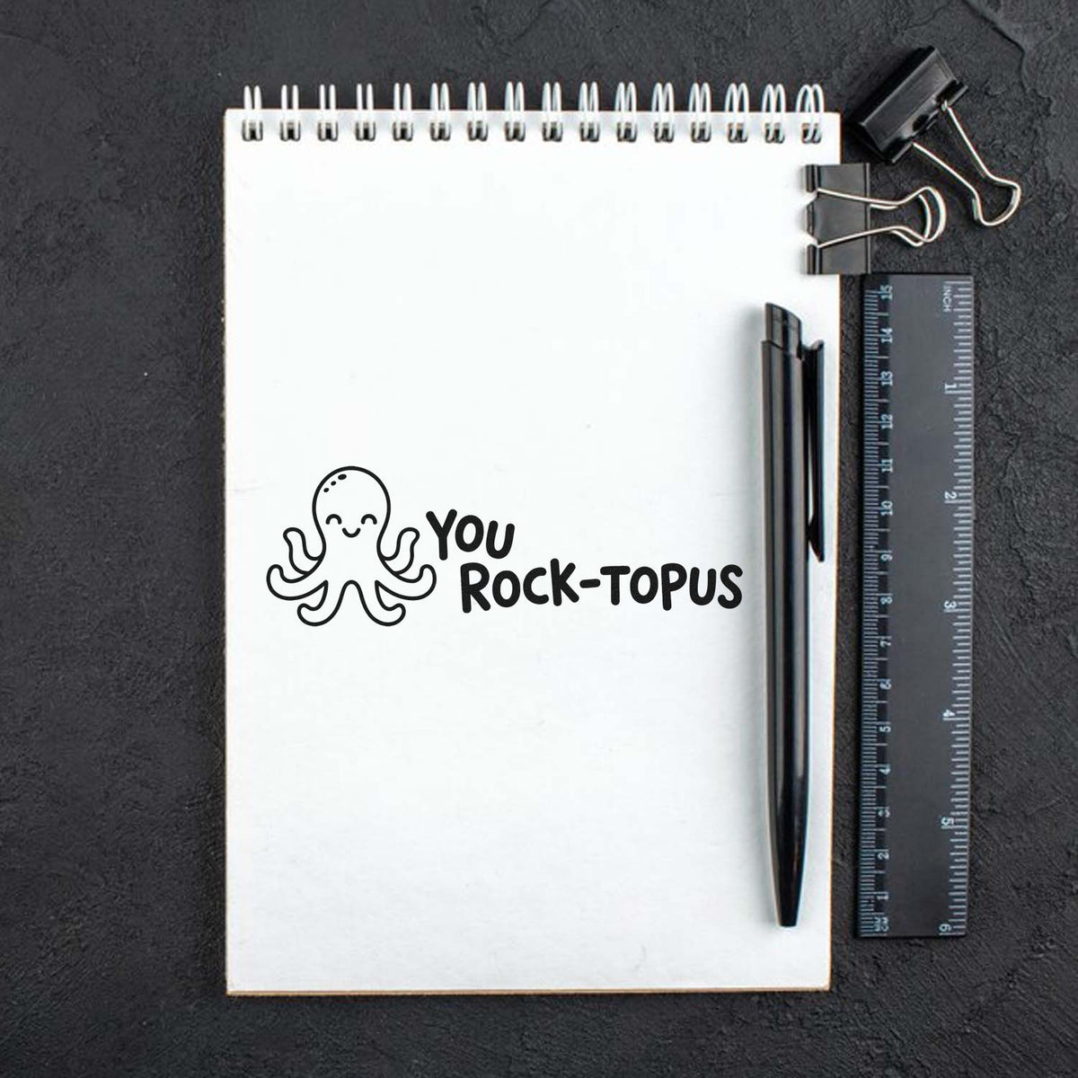 Octopus rubber stamp with You Rock-topus message, a fun teacher reward and encouragement stamp on a notebook.