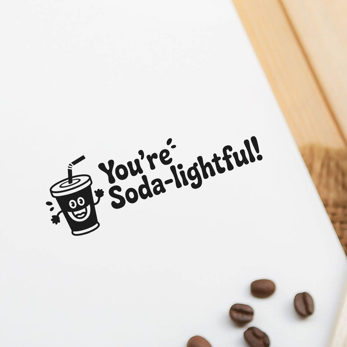 Custom rubber stamp impression with smiling soda cup and Youre Soda-lightful! text for fun packaging and craft projects.