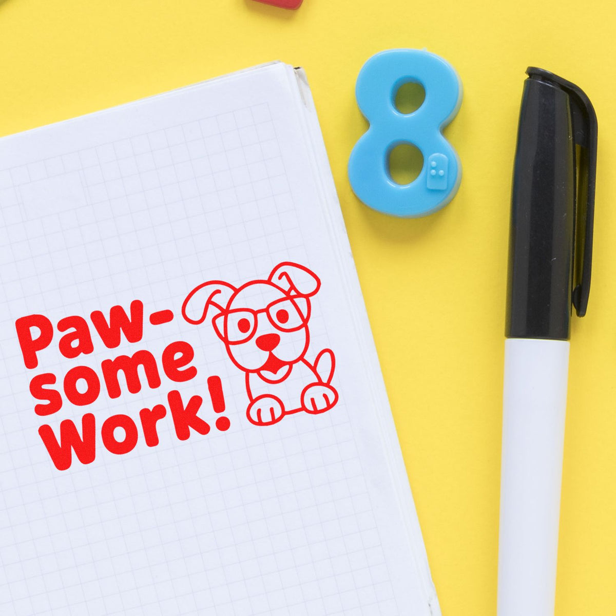 Paw-some Work rubber stamp on notebook with dog illustration, a fun teacher reward stamp for student praise.