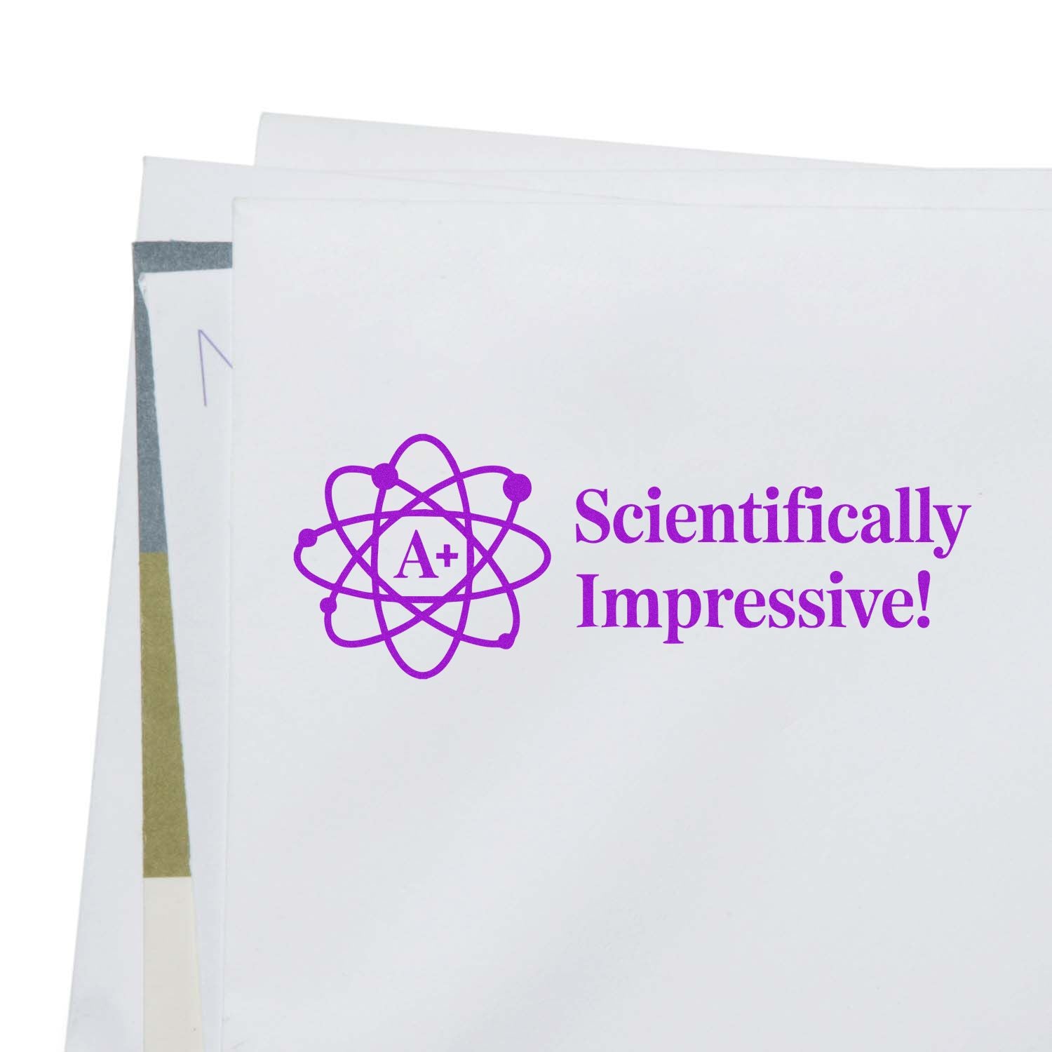 Purple Scientifically Impressive! rubber stamp with atom A+ design on paper for grading or science-themed messaging.